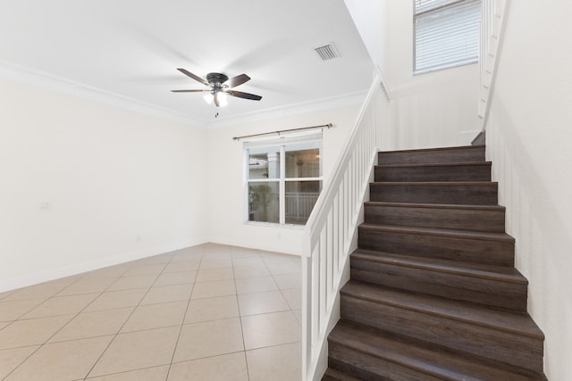 stairway with ceiling fan, tile patterned flooring, and ornamental molding