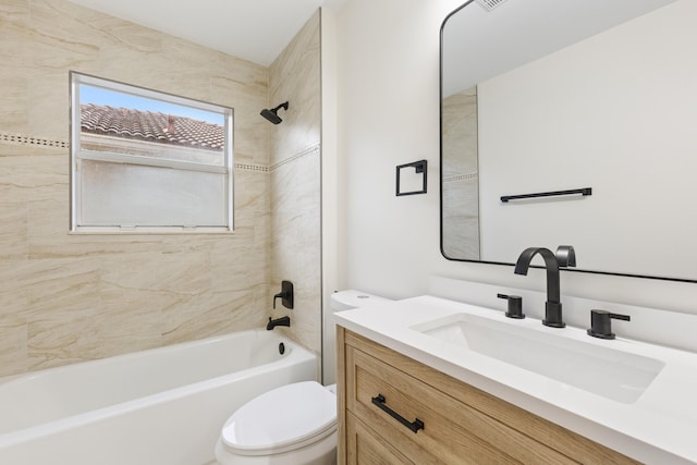 full bathroom with vanity, tiled shower / bath combo, and toilet