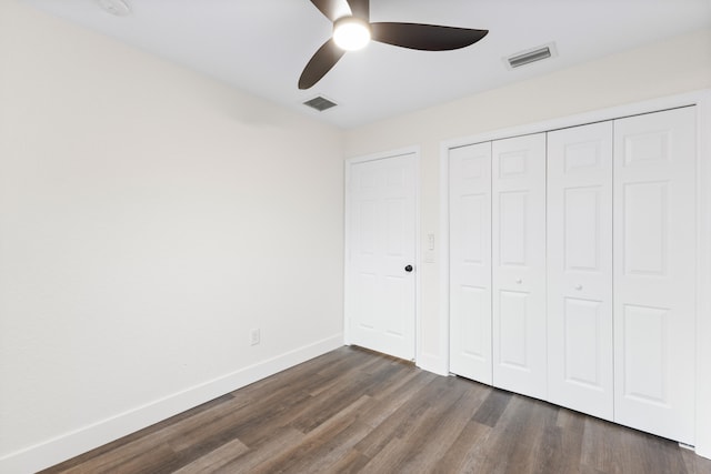 unfurnished bedroom with ceiling fan, dark hardwood / wood-style flooring, and a closet