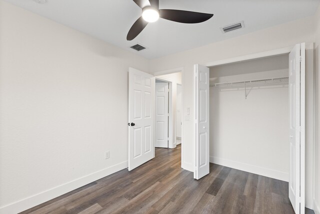 unfurnished bedroom with a closet, dark hardwood / wood-style floors, and ceiling fan