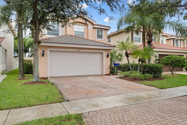 mediterranean / spanish house with a garage and a front lawn