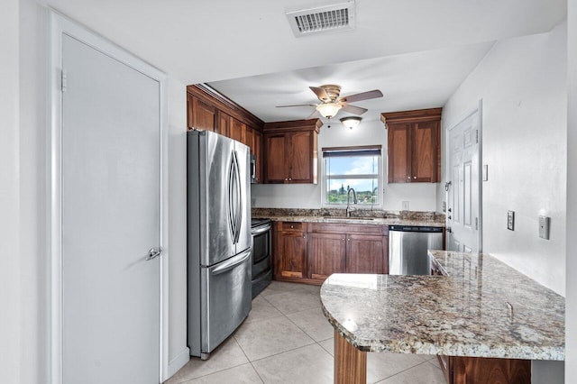 kitchen featuring kitchen peninsula, light stone countertops, a breakfast bar, stainless steel appliances, and sink