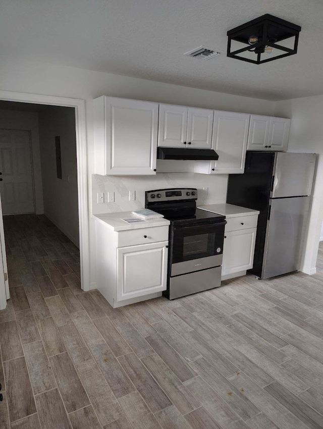 kitchen with appliances with stainless steel finishes, light hardwood / wood-style floors, and white cabinetry