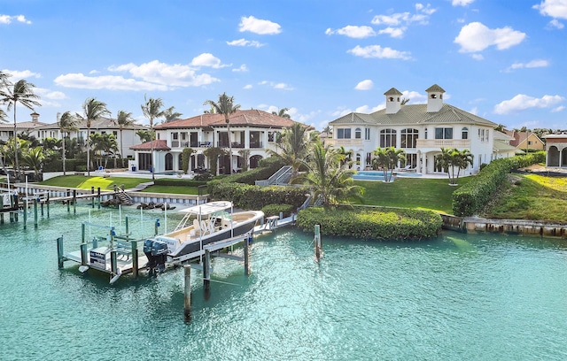 rear view of house featuring a yard, a water view, and a balcony