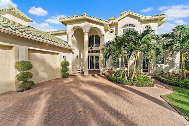 mediterranean / spanish house with french doors and a garage