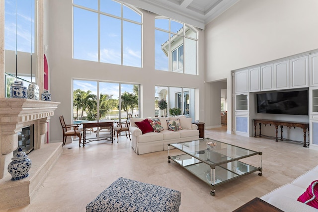 living room featuring ornamental molding, a high ceiling, and a high end fireplace