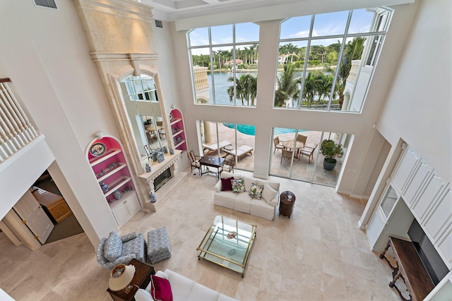 living room featuring a premium fireplace, a water view, and a high ceiling