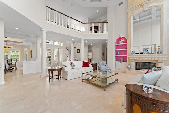 living room with a notable chandelier, a high end fireplace, a high ceiling, and ornamental molding