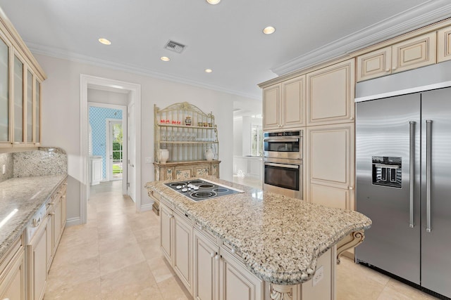 kitchen with a kitchen island, stainless steel appliances, and cream cabinets