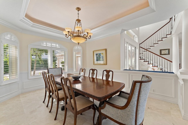 dining room with decorative columns, crown molding, a tray ceiling, and an inviting chandelier