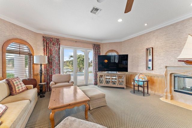 living room featuring a fireplace, carpet, and ornamental molding