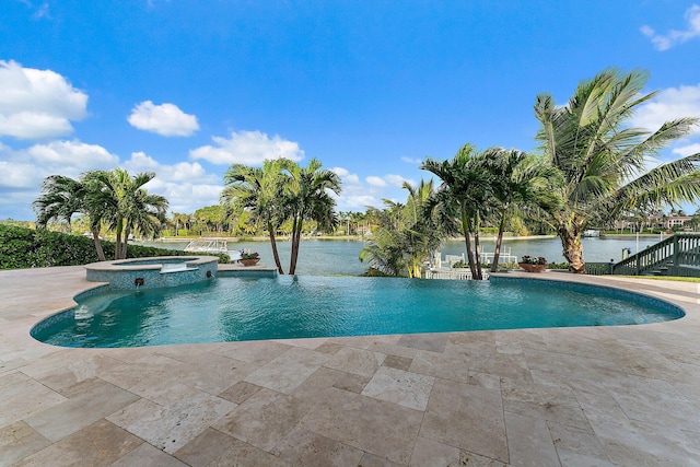 view of swimming pool with an in ground hot tub, a water view, and a patio