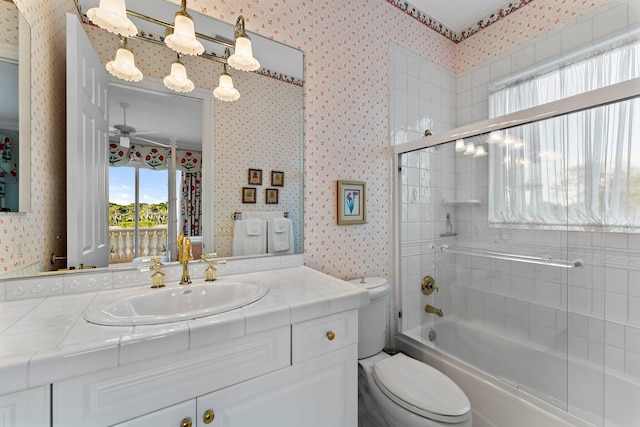 full bathroom featuring shower / bath combination with glass door, ceiling fan, vanity, and toilet