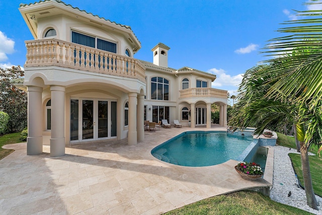 back of house with french doors, a balcony, and a patio area