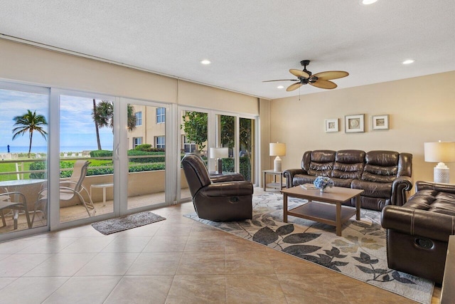 living room featuring ceiling fan, light tile patterned floors, a textured ceiling, and french doors