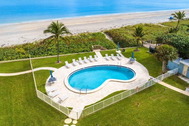 view of swimming pool with a view of the beach, a water view, and a patio area