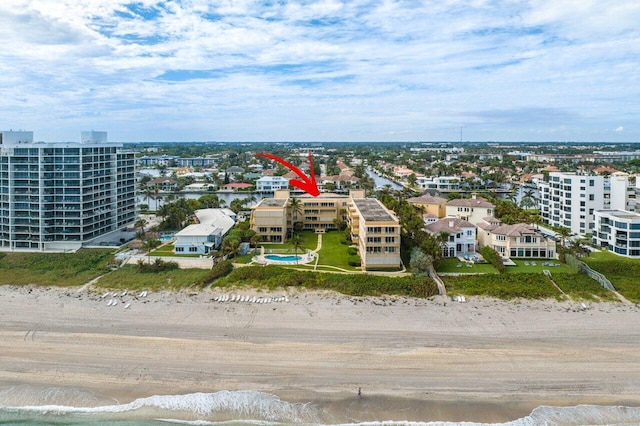 birds eye view of property with a water view and a beach view