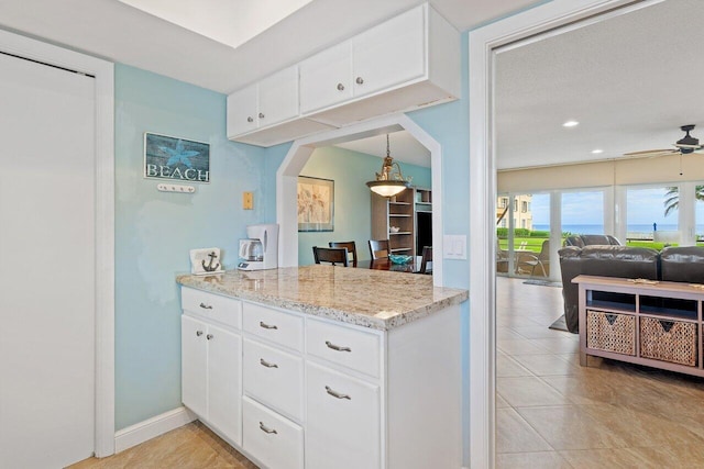 kitchen featuring white cabinets, pendant lighting, light tile patterned floors, and ceiling fan