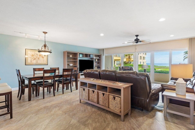 living room with ceiling fan and plenty of natural light