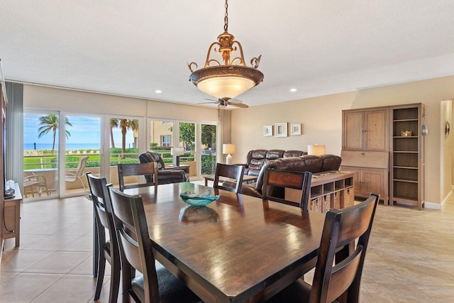 dining area with ceiling fan, light tile patterned flooring, and a textured ceiling