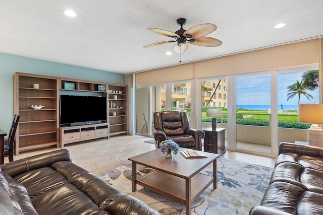 tiled living room featuring ceiling fan and a textured ceiling