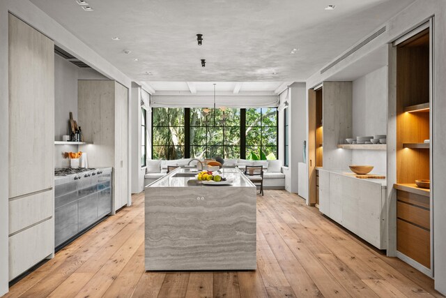 kitchen with high end stove, a kitchen island, and light hardwood / wood-style floors