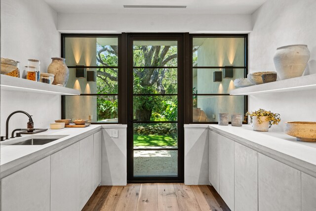 doorway to outside with sink and light hardwood / wood-style floors