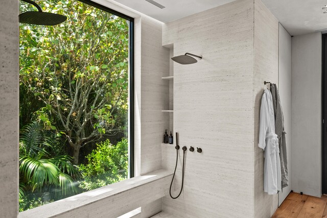 bathroom featuring walk in shower, a healthy amount of sunlight, and hardwood / wood-style flooring