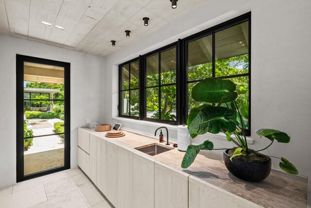 interior space featuring light stone countertops and sink