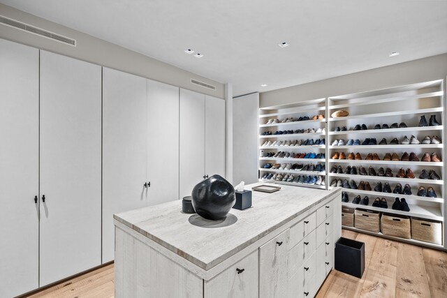 walk in closet with light wood-type flooring