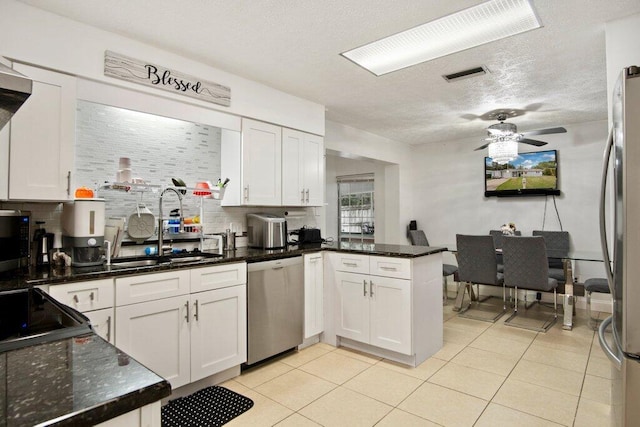 kitchen with kitchen peninsula, white cabinetry, and stainless steel appliances