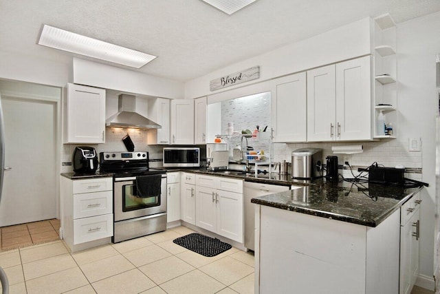 kitchen featuring white cabinets, wall chimney exhaust hood, appliances with stainless steel finishes, tasteful backsplash, and light tile patterned flooring