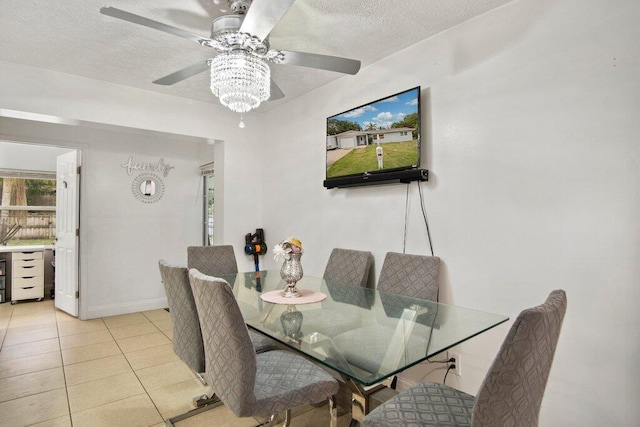 tiled dining area with a textured ceiling and ceiling fan