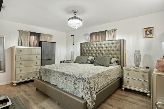 bedroom featuring dark hardwood / wood-style flooring and an inviting chandelier