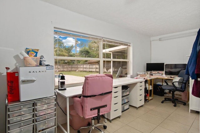 tiled office space featuring a textured ceiling