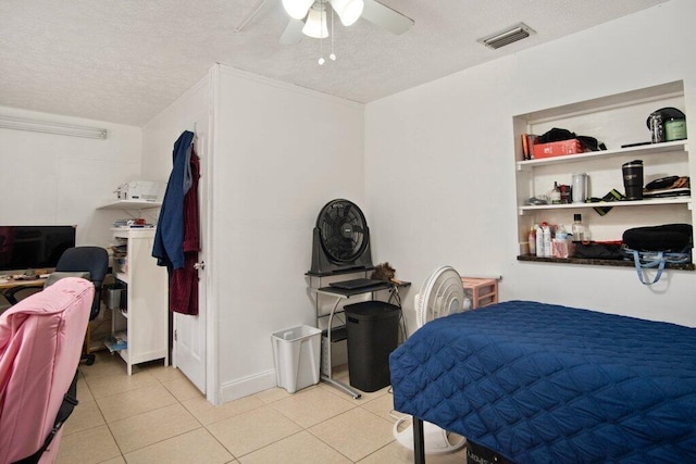 tiled bedroom with ceiling fan and a textured ceiling