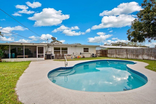 view of pool featuring a patio, a lawn, and a sunroom