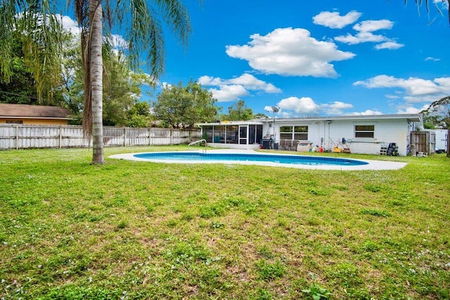 back of house featuring a fenced in pool, a sunroom, and a lawn