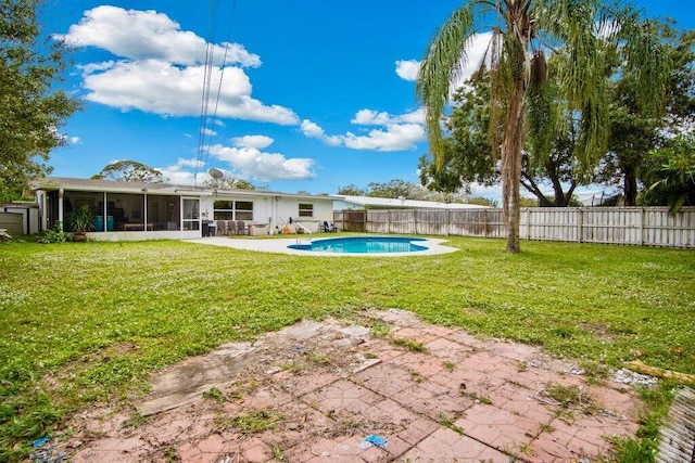 view of yard featuring a fenced in pool, a patio area, and a sunroom