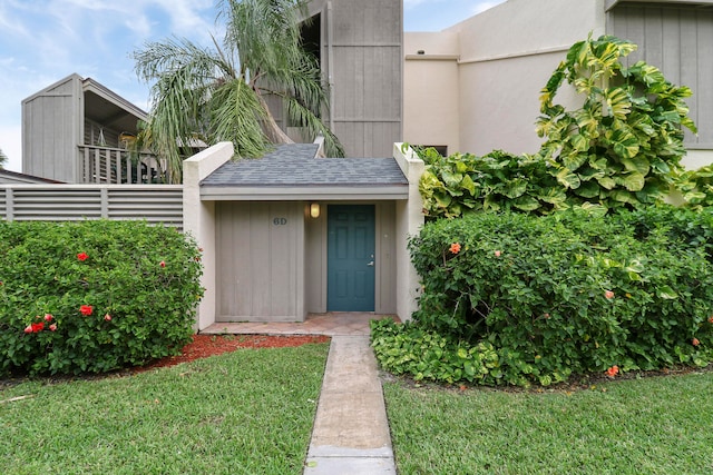 entrance to property featuring a lawn