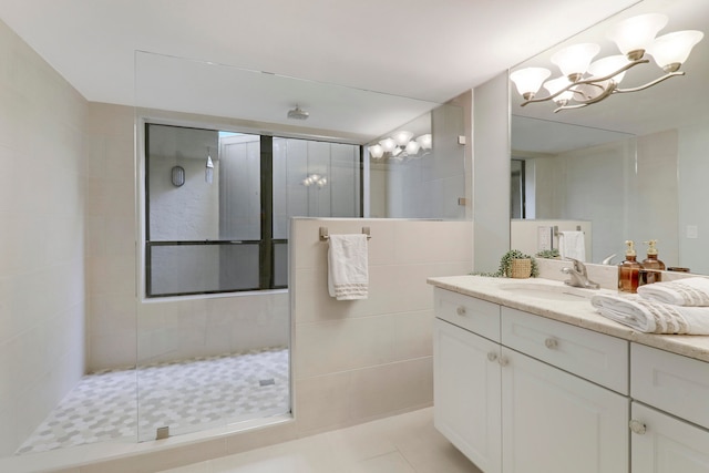 bathroom featuring a shower, tile patterned flooring, vanity, and tile walls