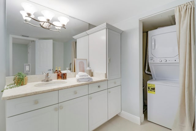 bathroom featuring vanity, stacked washing maching and dryer, and a notable chandelier