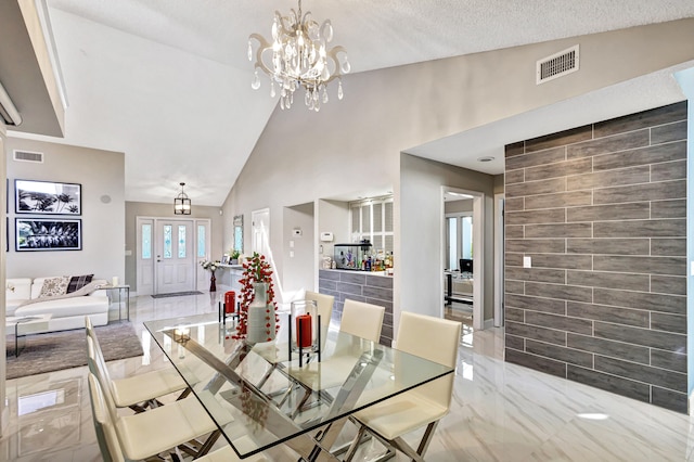 dining room with a notable chandelier, a textured ceiling, and vaulted ceiling