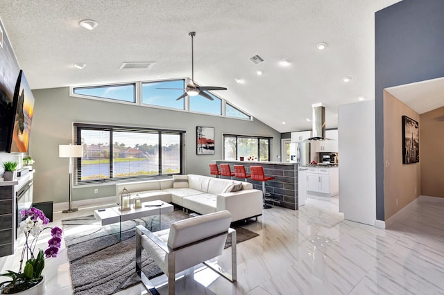 living room with ceiling fan, high vaulted ceiling, and a textured ceiling