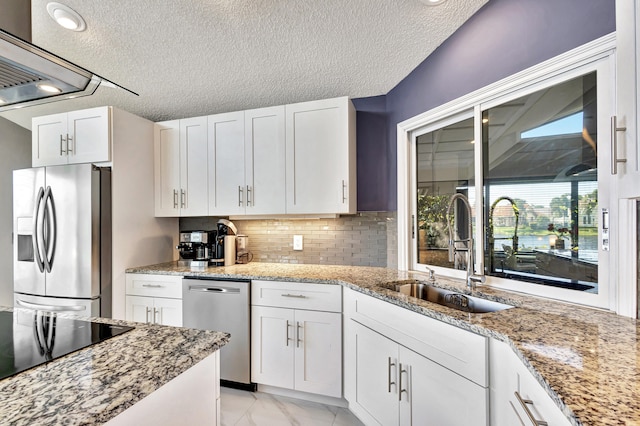 kitchen with white cabinets, black electric stovetop, a water view, a textured ceiling, and island range hood