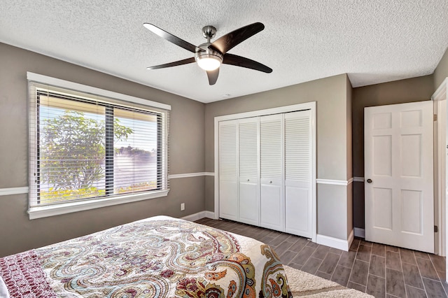 bedroom featuring a textured ceiling, a closet, ceiling fan, and dark hardwood / wood-style floors