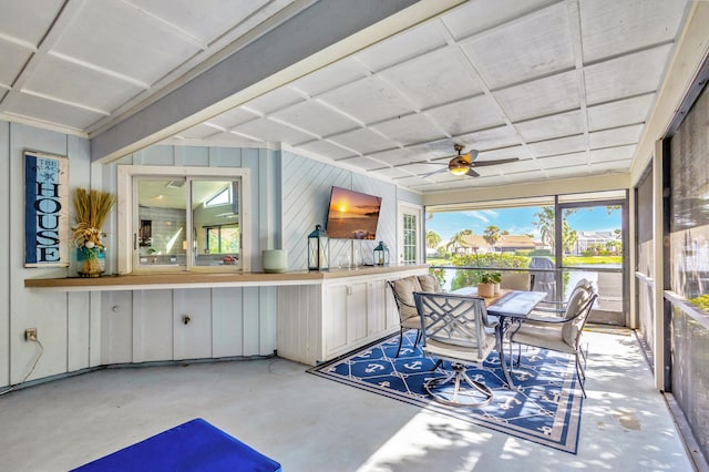 unfurnished sunroom with ceiling fan