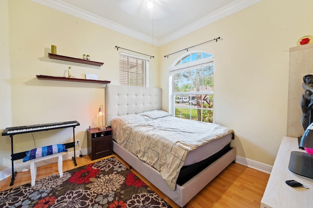 bedroom featuring light wood-type flooring and crown molding