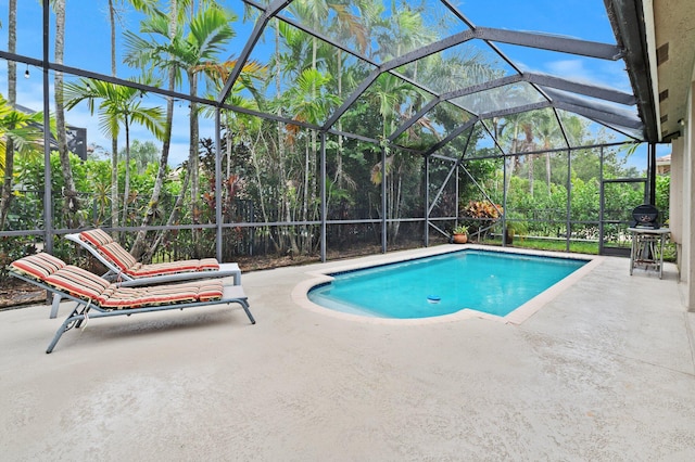 view of swimming pool featuring glass enclosure, area for grilling, and a patio