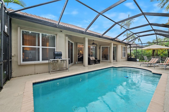 view of swimming pool with ceiling fan, a patio area, and a lanai